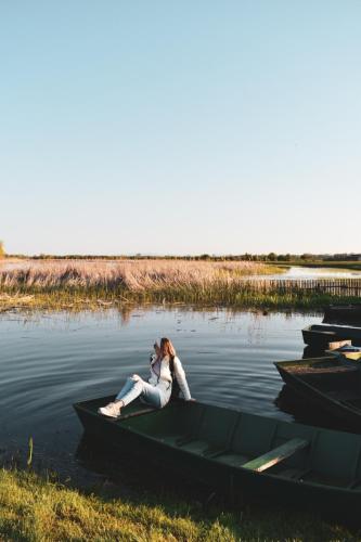 a woman sitting on a boat in the water at Amanet House Zasavica in Zasavica