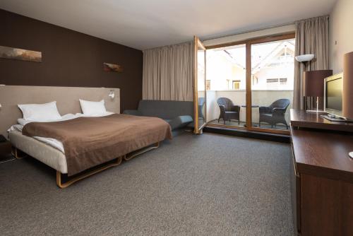 ブワディスワボボにあるApartamenty Apartinfo Velaのベッドとテレビが備わるホテルルームです。