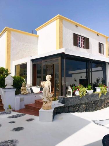 a house with a statue in front of it at HOTELITO RURAL GA7COLORES only adult in Montaña Blanca