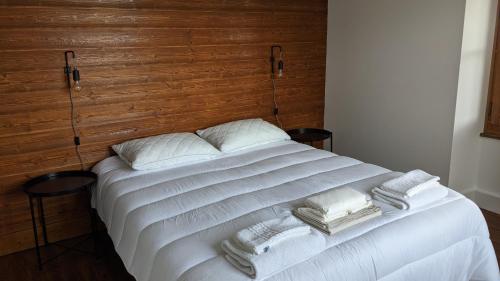 a white bed with two pillows and towels on it at Gîte Les Vernes du Léman 11 à 13 pers in Maxilly-sur-Léman