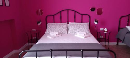 Dormitorio rosa con cama grande y paredes rosas en B&B Stella Scugnizza, en Nápoles