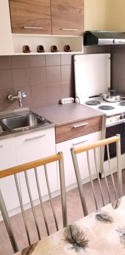 a kitchen with a sink and two chairs at Apartment PER DAY in Vrbas