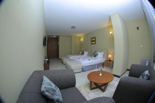 a bedroom with a bed and a couch and a table at Daisy Hotel in Addis Ababa