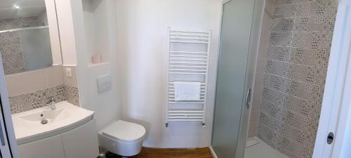a white bathroom with a toilet and a sink at Gîte Les Vernes du Léman 11 à 13 pers in Maxilly-sur-Léman