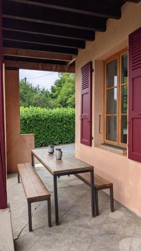 a wooden table and benches sitting on a patio at Gîte Les Vernes du Léman 11 à 13 pers in Maxilly-sur-Léman