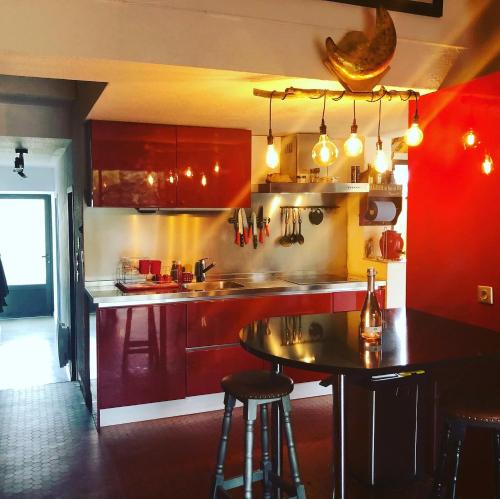 una cocina con armarios rojos y una mesa. en La cabane de Biscarrosse en Biscarrosse-Plage