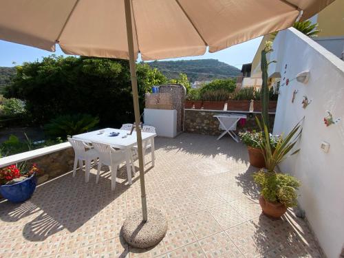 a patio with a table and an umbrella at PonzaSmeralda Le Forna in Ponza