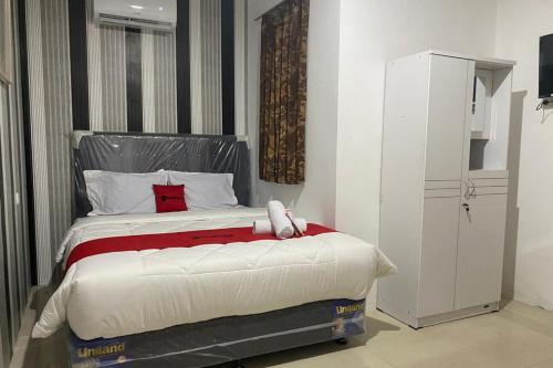a bedroom with a bed with a teddy bear on it at RedDoorz Plus @ Rawamangun in Jakarta