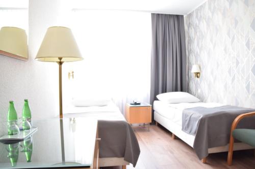 a hotel room with two beds and a table at Hotel Festival in Opole