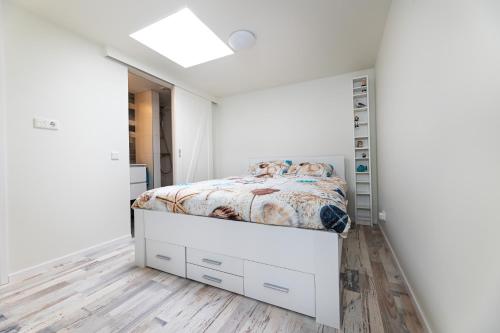 een slaapkamer met een bed in een witte kamer bij Vakantiewoning B & Bernard in Domburg