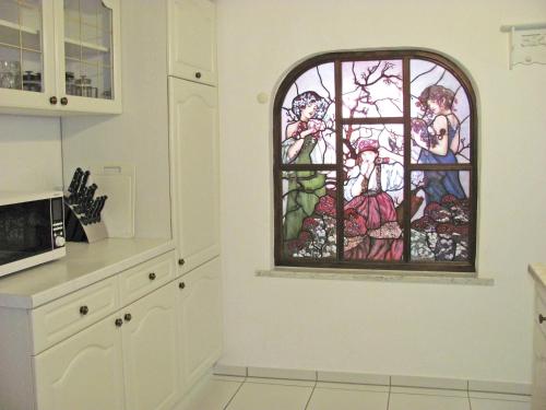 a kitchen with a stained glass window on the wall at Apartment Storchenfärbe in Memmingen