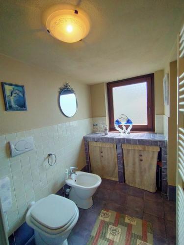 a bathroom with a toilet and a sink at L'Atelier du Temps - Tzi Voycas in Gignod