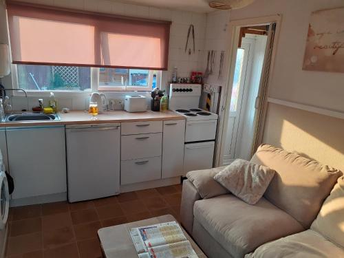a kitchen with a couch and a stove top oven at Mablethorpe Chalet in Mablethorpe