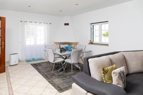 a living room with a couch and a table with chairs at NuvemCristina in Olho Marinho