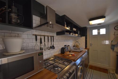 a kitchen with black cabinets and a stove top oven at Matchbox in Winchelsea