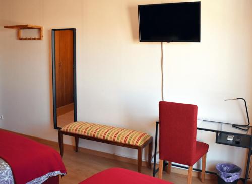 a room with a chair and a tv on a wall at Batalhoz House II in Cartaxo