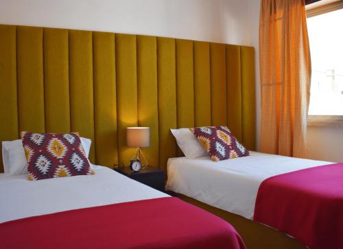 une chambre d'hôtel avec deux lits et un mur jaune dans l'établissement Batalhoz House II, à Cartaxo