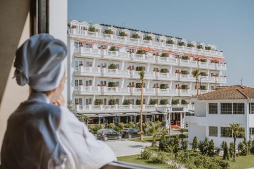 Flower Hotels & Resorts في غوليم: امرأة تطل من النافذة على فندق