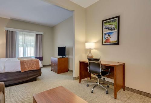 a hotel room with a bed and a desk and a chair at Comfort Inn & Suites Augusta Fort Eisenhower Area in Augusta
