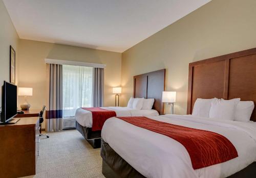 a hotel room with two beds and a television at Comfort Inn & Suites Augusta Fort Eisenhower Area in Augusta