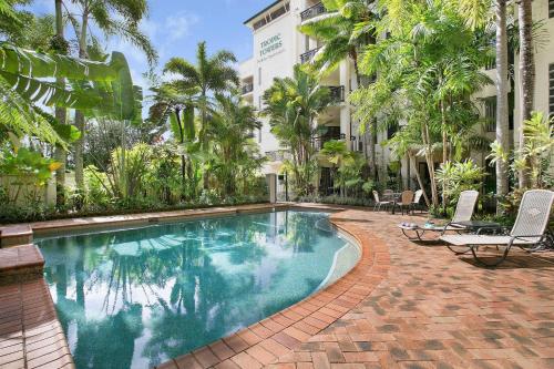 a swimming pool in front of a building at Tropic Towers Apartments in Cairns