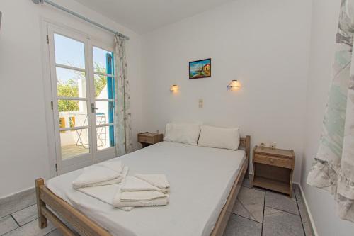 um quarto com uma cama e uma janela em villa polemis em Agia Anna (Naxos)