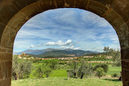 a view of a city through a stone archway at Hostería de Guara in Bierge