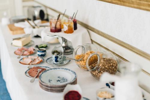 a table topped with plates and bowls of food at Trollnäs Gårdshotell in Svärdsjö