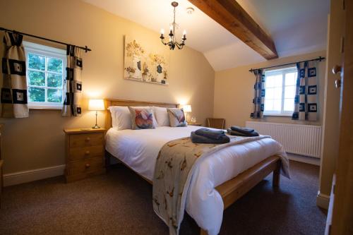 a bedroom with a large bed and two windows at The Coach House in Martin