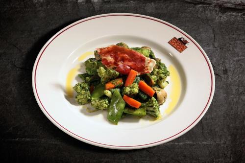 a white plate of food with broccoli and carrots at Hostería de Guara in Bierge