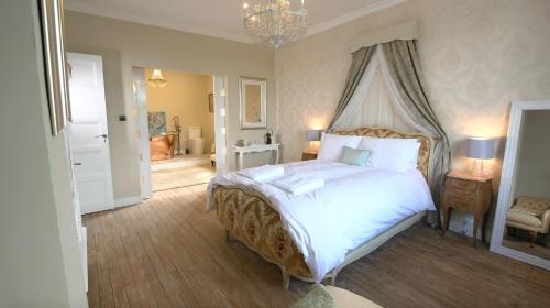 um quarto com uma cama grande e um lustre em R & R BERGERAC em Bergerac