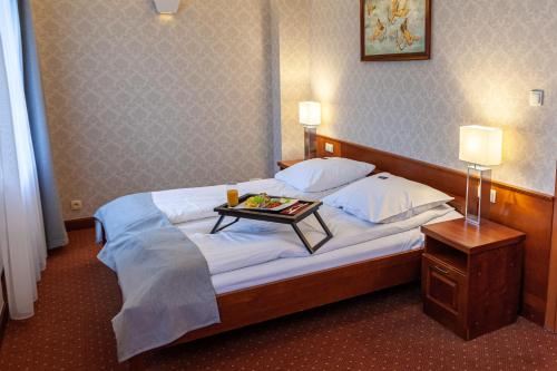 a hotel room with a bed with a tray of food on it at Eurohotel Swarzędz in Swarzędz