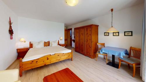 a bedroom with a bed and a table in a room at Hotel Seepark Appartements in Uhldingen-Mühlhofen