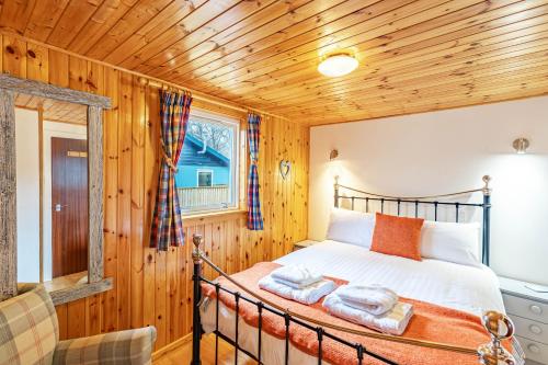 a bedroom with a bed with towels on it at Bracken Lodge 6 with Hot Tub in Belladrum