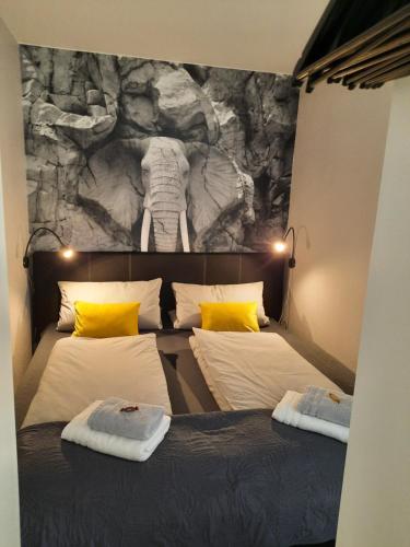 a bedroom with two beds and an elephant mural at Meisters Schick im Stryck Willingen in Willingen
