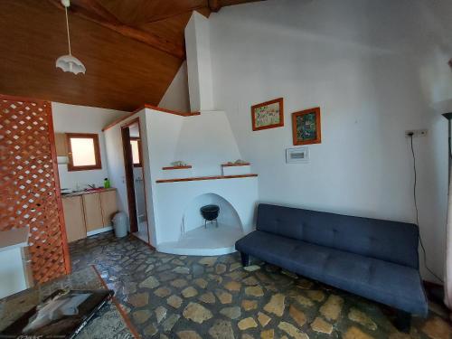 a living room with a couch and a fireplace at Beautiful house located on a hill with a spectacular sea view in Samos Island in Koumeika