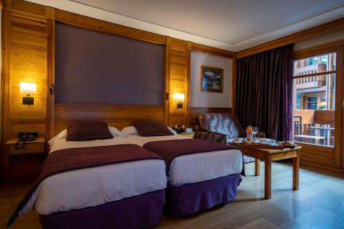 a bedroom with a large bed and a large window at Hotel Nordic in El Tarter