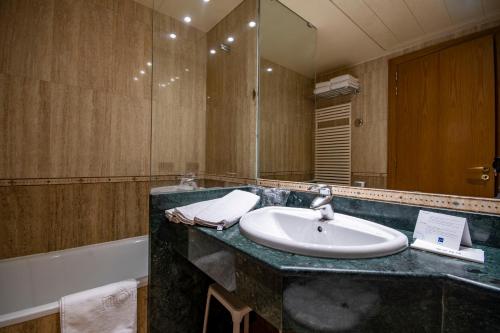 a bathroom with two sinks and a large mirror at Hotel Nordic in El Tarter