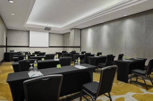 a conference room with tables and chairs and a screen at Holiday Inn Singapore Atrium by IHG in Singapore