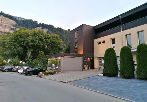a building with cars parked in a parking lot at Business Apartments in Hohenems