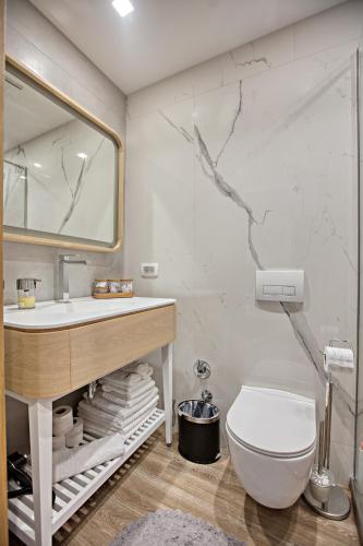 a bathroom with a sink and a toilet and a mirror at OLD TOWN Apartments by Nejra in Sarajevo