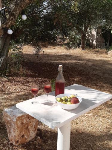 una mesa con un bol de fruta y dos copas de vino en Casa Baronessa, en Ceglie Messapica