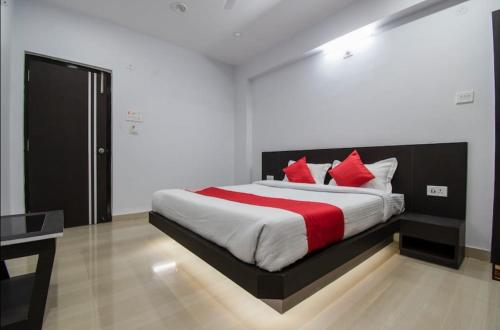 a bedroom with a large bed with red pillows at S G INTERNATIONAL PATNA in Patna