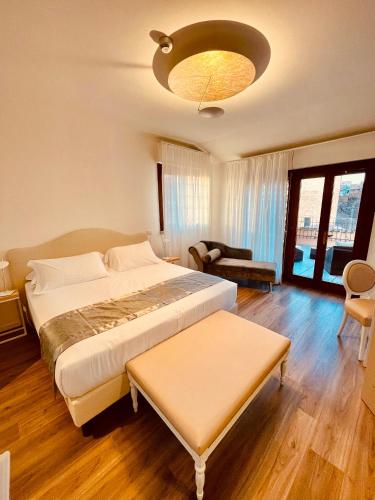 a bedroom with a large bed and a living room at Grand Hotel San Lorenzo in Mantova