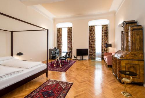 a bedroom with a bed and a desk in a room at Boutique Hotel Dom - Rooms & Suites in Graz
