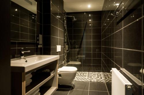 een zwarte badkamer met een toilet en een wastafel bij Golden Mansion Aparthotel in Amsterdam
