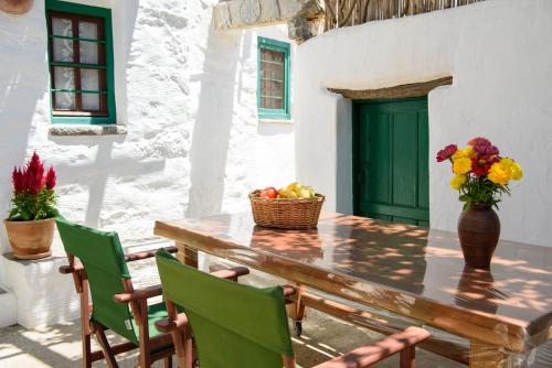 a table with a vase of flowers and a basket of fruit at Itonia House in Amorgos