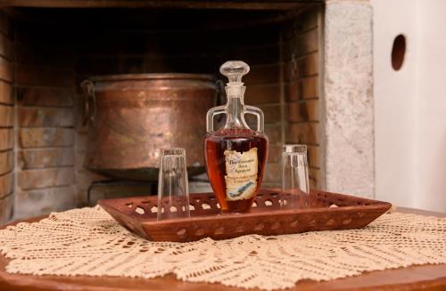 a bottle of bourbon sitting on a tray with two glasses at Itonia House in Amorgos
