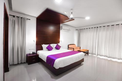 a bedroom with a large bed with purple sheets at Malabar Ocean Front Resort And Spa, Bekal in Nīleshwar