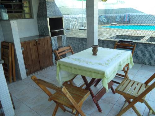 a table and chairs on a patio with a pool at Pisco Chalés in Ubatuba